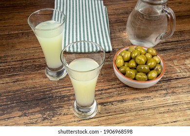 glass of Pastis on a wooden table - Shutterstock ID 1906968598