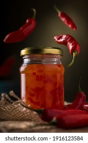 Glass Of Pepper Jelly With Flying Peppers.