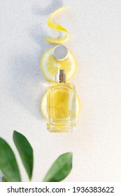 Glass Perfume Bottle With Lemon Slices , Zest And Green Leaves On Light Background Citrus Summer Fragrance Concept