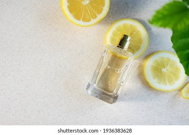 Glass Perfume Bottle With Lemon Slices , Zest And Green Leaves On Light Background Citrus Summer Fragrance Concept, Copy Space