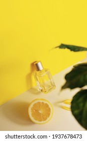 Glass Perfume Bottle With Lemon Slices , Zest And Green Leaves On Yellow Background Citrus Summer Fragrance Concept, Vertical