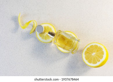 Glass Perfume Bottle With Lemon Wedges And Zest On Light Background Citrus Summer Fragrance Concept