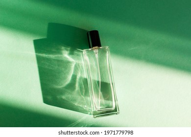  Glass Perfume Bottle On Green Background With Shadows. Unisex Perfume Concept