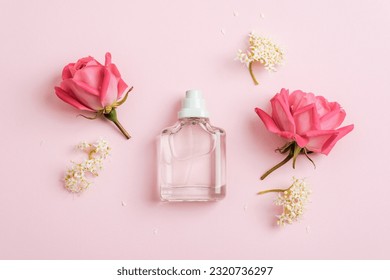 Glass perfume bottle and rose flowers on pink background. Top view, flat lay, mockup. - Shutterstock ID 2320736297