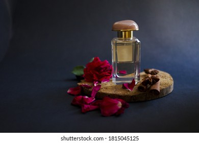 
glass perfume bottle with rose and petals on dark background lit in low key - Shutterstock ID 1815045125