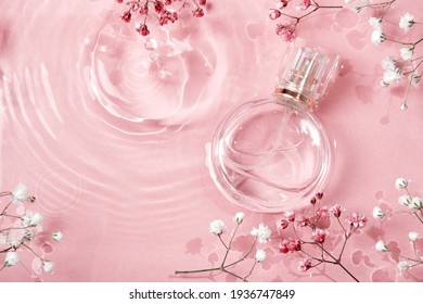 Glass perfume bottle in rose water background. Floral arrangement, splash of water - Powered by Shutterstock