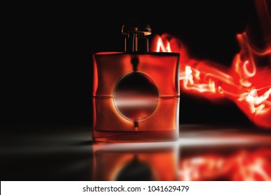 Glass of perfume on a dark background in flames