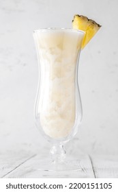 Glass Of Pina Colada Cocktail Garnished With Pineapple Wedge