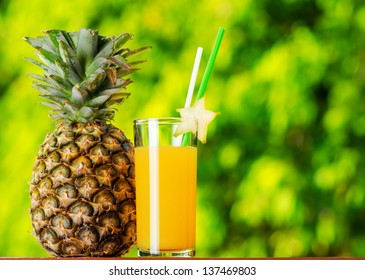 Glass Of Pineapple Juice In A Garden.