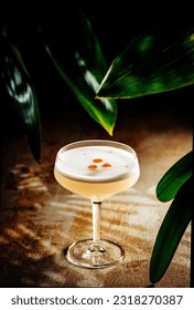 Glass of Pisco Sour surrounded by plants
