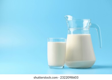 Glass and pitcher of fresh milk on  light blue background. - Powered by Shutterstock