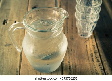 Glass Pitcher Of Water And Glass On Wooden Table Background, Vintage Color Tone.