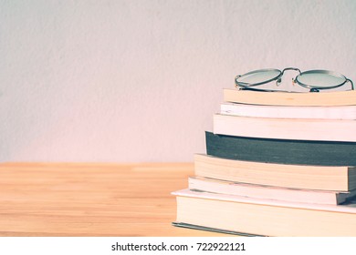  glass placed on the books and on the wood table ,vintage filter , education and business concept. - Shutterstock ID 722922121