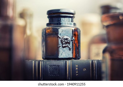 Glass poison bottle with skull and bones. Danger sign, symbol of death. Concept background on poison poisoning, pharmaceutical, chemistry, medical, old science topic.