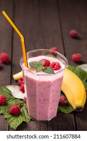 Glass Of Raspberry Banana Smoothie On Wooden Table