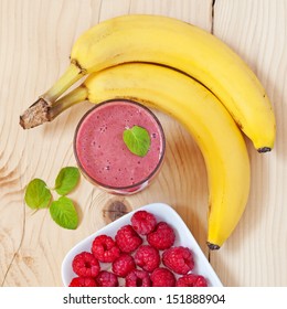 A Glass Of Raspberry Smoothie With Fresh Raspberries, Mint Leaves And Banana