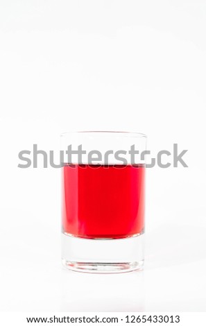 a glass of red alcohol on white background