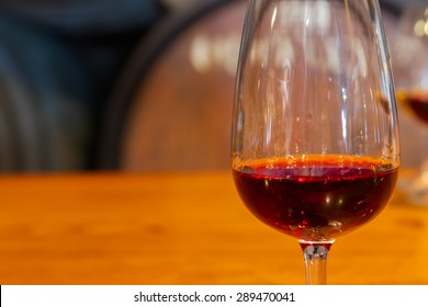 Glass Of  Red Port Wine With Barrels In Background