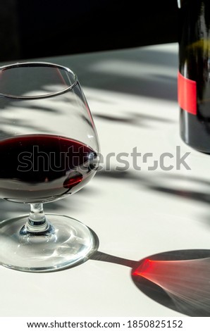 glass of red ruby port wine on white table