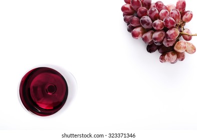 Glass Of Red Wine With Bunch Of Grapes, Overhead On White Background, Minimalist Arrangement