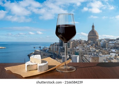 Glass of red wine with cheese with view of Valletta old town and harbor in Valletta, Malta. - Shutterstock ID 2166584239