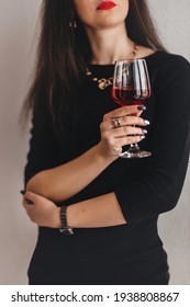 Glass of red wine close-up in the hands of a beautiful girl