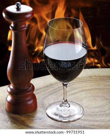 Glass of red wine and a fireplace in the background