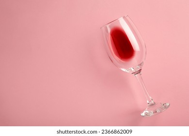 Glass with red wine lying on pink background, top view. Space for text - Powered by Shutterstock