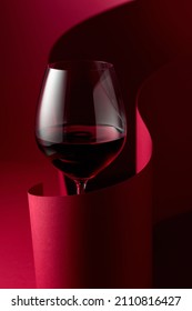Glass Of Red Wine On A Red Background.