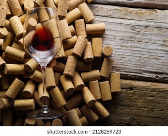 Glass With Red Wine On The Background Of Wine Corks. Wooden Texture. Close-up. There Are No People In The Photo. Restaurant, Bar, Party, Vineyard, Wine Collection, Tasting, Banquet. Banner.