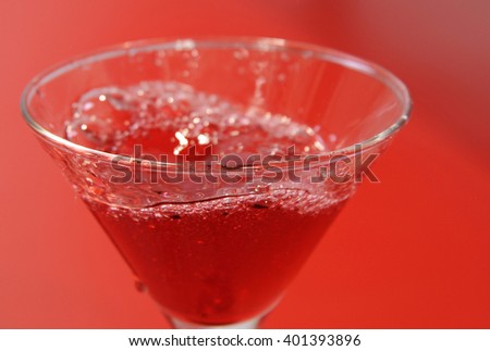 Glass of red wine on a red background