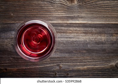 Glass Of Red Wine On Dark Wooden Background From Top View