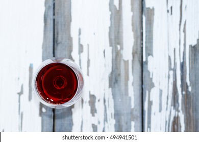 Glass Of Red Wine On A White Background Wooden