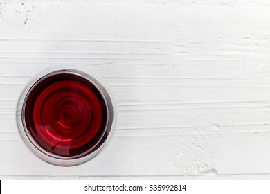 Glass Of Red Wine On White Wooden Background From Top View