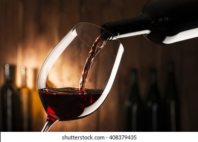 glass with red wine on wooden background