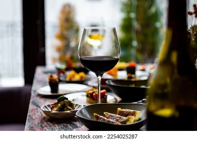 glass with red wine and wine snack set, food from spain, cheese, meat, vegetables and other appetizers on table - Powered by Shutterstock