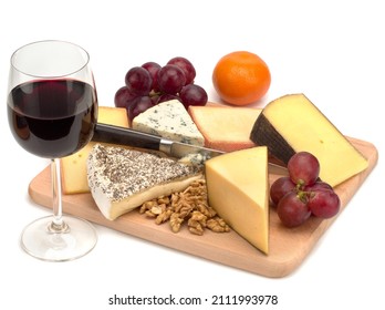 A glass of red wine and a wooden board with cheese, nuts and grapes - Shutterstock ID 2111993978