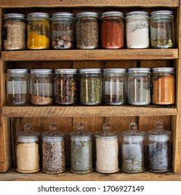 Glass Reusable Spice Jars In A Rustic Wooden Cabinet