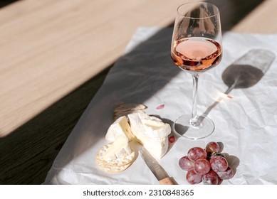 A glass of rose wine with appetizers on a white background. - Shutterstock ID 2310848365