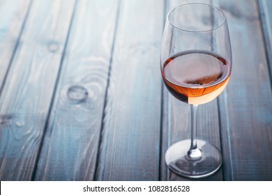 Glass Of Rose Wine On A Blue Wooden Table At A Bar