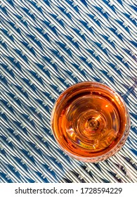 Glass Of Rose Wine Viewed From Above On The Glass Table Top Of Garden Furniture