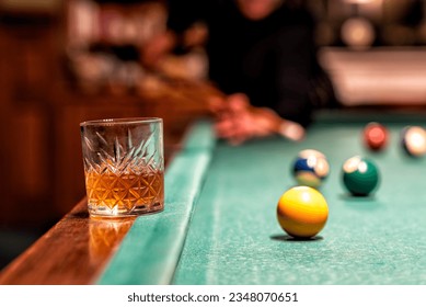 glass of Rum on a billiard table in an old castle with billiard balls and billiards cues