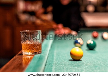 glass of Rum on a billiard table in an old castle with billiard balls and billiards cues