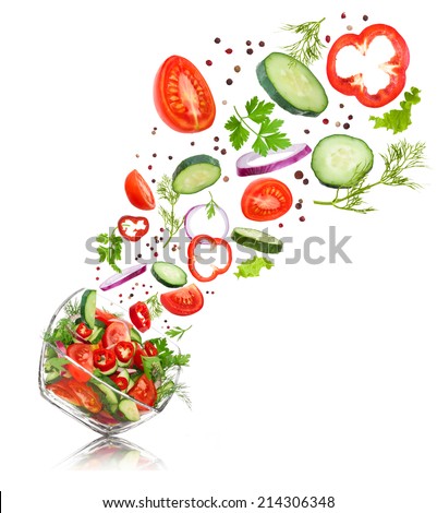 glass salad bowl in flight with vegetables: tomato, pepper, cucumber, onion, dill and parsley. Isolated on white background