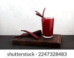 Glass of Salgam on wooden cutting board. Popular Turkish drink. Traditional beverage made with water, purple carrot or turnip (juice). Natural probiotic drink.