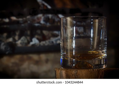 Glass Of Scotch Whiskey In Front Of The Fire