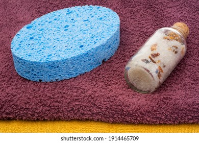 A Glass Of Sea Salt With Bath Sponge Isolated On Towel