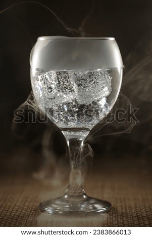 Glass with soda and ice with smoke effect.
