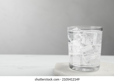 Glass Of Soda Water With Ice On White Table. Space For Text