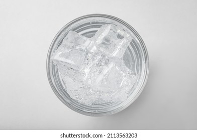 Glass Of Soda Water With Ice On Light Background, Top View